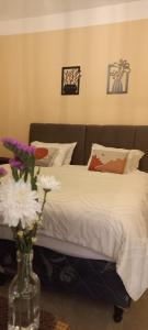 a bedroom with a bed with a vase of flowers at Casa Centro Tilcara in Tilcara