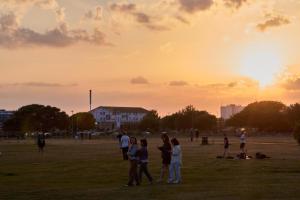 a group of people standing in a field at sunset at Coastal Comfort for 5 in Portsmouth