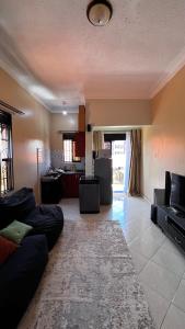 a living room with a couch and a tv at Comfy Square in Kampala