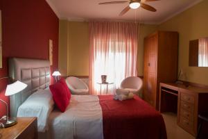 a bedroom with a bed with two chairs and a window at Las Casas de Nani in Beas de Segura