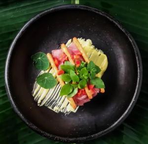 a black plate topped with food on top of pasta at Renacer in Termales - agua caliente - nuqui +26 photos