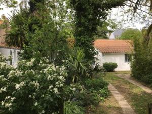 a garden with white flowers in front of a house at Résidence agréable proche de la mer in Saint-Gervais