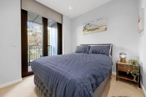 a bedroom with a blue bed and a window at Northern Quarter Modern Apartment in Manchester