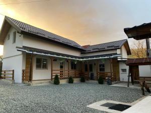 a house with a gravel driveway in front of it at Cabana La Batranu-ciubar&atv in Borşa