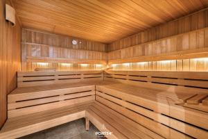 a wooden sauna with wooden benches and a wooden ceiling at Maybach Suite Westerland auf Sylt in Westerland