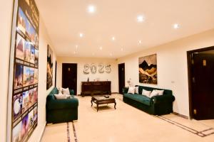 a living room with two green couches and a piano at Solima pyramids inn in Cairo
