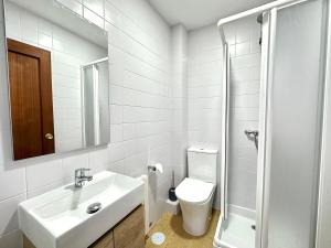 Un baño blanco con lavabo e inodoro. en Patos Sunset Beach House, en Nigrán 13 fotos más