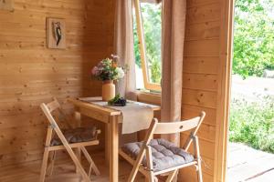a dining room with a table and two chairs at Ganu Namiņš in Ķurbes Ciems