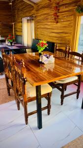 a large wooden table with benches and flowers on it at Haveli Dhaba and Resort in Sānwer