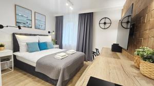 a bedroom with a bed with blue pillows on it at Mini Apartament Lipperta in Szczytno