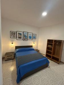 a bedroom with a blue bed and a cabinet at Massi's House - Cozy & New in Maiori