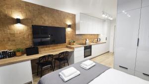 a room with a bed and a kitchen with a counter at Mini Apartament Lipperta in Szczytno