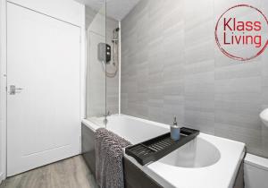 a bathroom with a bath tub and a sink at Colt Apartment by Klass Living Coatbridge in Glenboig