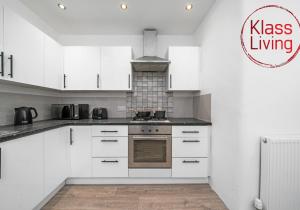 a kitchen with white cabinets and a stove at Colt Apartment by Klass Living Coatbridge in Glenboig +25 photos