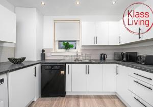 a kitchen with white cabinets and a black dishwasher at Colt Apartment by Klass Living Coatbridge in Glenboig