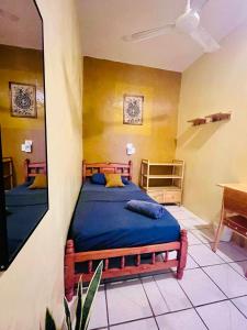 a bedroom with two beds with blue sheets and yellow walls at Palmar la Punta 5 Starlink 2min walk to the beach in Brisas de Zicatela