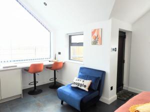 a bedroom with a blue chair and a desk at Pentagram Studio in Lewes