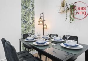 a dining room with a table with chairs and glasses at Drumpellier Apartment by Klass Living Coatbridge in Coatbridge