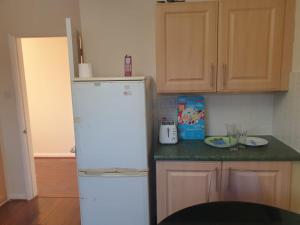 a kitchen with a white refrigerator and a counter at Staycation Bunglaw in Coppingford +6 photos