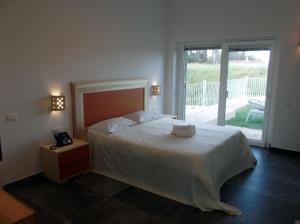 a bedroom with a large bed and a balcony at Amarena Garden House in Matera