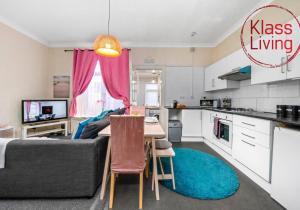 a kitchen and living room with a couch and a table at Elmbank Apartment by Klass Living Bellshill in Bellshill