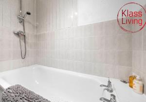 a bathroom with a bath tub and a sink at Elmbank Apartment by Klass Living Bellshill in Bellshill +16 photos