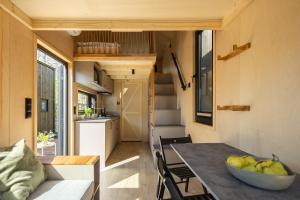 a tiny house with a table and a kitchen at Chalëpë 20 - komfortowe domki "Tiny House" in Chałupy