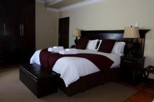 a bedroom with a large bed with a wooden headboard at Goodey's Guesthouse in Pretoria +57 photos