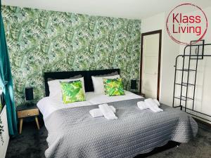 a bedroom with a large bed with towels on it at Elmbank Avenue House by Klass Living Uddingston in Uddingston