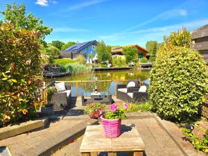 De Poort van Zeeland aan het water met jacuzzi في سينت انالاند: فناء خلفي مع طاولة مليئة بالزهور وبركة +46 صورة
