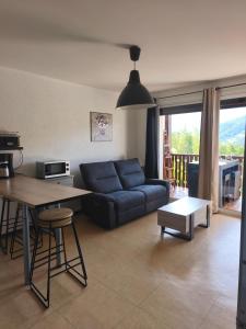 salon z niebieską kanapą i stołem w obiekcie Location vacances Barcelonette w mieście Barcelonnette