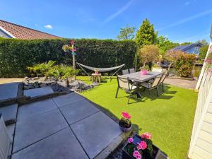 De Poort van Zeeland aan het water met jacuzzi في سينت انالاند: حديقة فيها أرجوحة وطاولة وكراسي