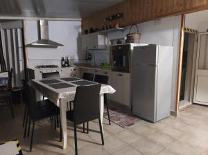a kitchen with a table and a white refrigerator at Vista cielo in Palagiano