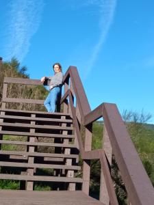a young child sitting on top of a wooden bridge at Casa O Arco Alojamento Local in Marvão
