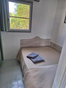 a small bed in a room with a window at Altaria in Porto-Vecchio