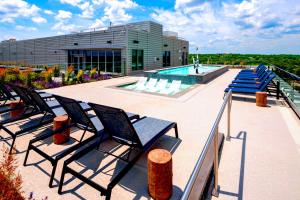 Un grupo de sillas junto a una piscina. en Comfy Clarendon Apt - Steps from Metro, en Arlington