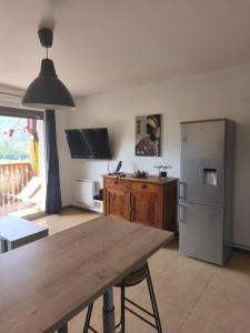 kuchnia z drewnianym stołem i lodówką w obiekcie Location vacances Barcelonette w mieście Barcelonnette +5 zdjęć