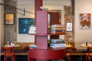 a pink book shelf with books on it in a restaurant at Hotel Pilar in Antwerp