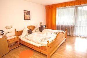 a bedroom with a wooden bed and a large window at Waldhotel Auerhahn B&B Bed & Breakfast in Eisenbach