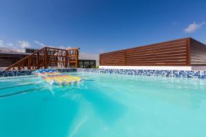 a swimming pool with umbrellas in the water at central and quiet apartment playa in Playa del Carmen