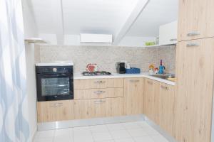 a kitchen with wooden cabinets and a black oven at Agropoli Home in Agropoli