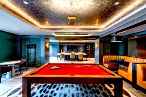 una sala de billar con una mesa de billar rojo en Comfy Clarendon Apt - Steps from Metro, en Arlington