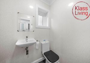 a bathroom with a sink and a toilet and a mirror at Fraser House by Klass Living Rutherglen in Glasgow
