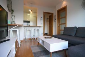 a living room with a couch and a table at Piscina y garaje cerca del centro by CABANA Rentals in Vigo