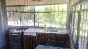 a kitchen with a stove and a sink next to a window at Hostel "La Casa de Ricky" in Caraz