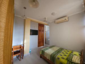 a bedroom with a bed and a desk in it at Rosa Victoria in Tarapoto