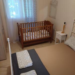 a baby crib in a room with a bedroom at Villa Nikos in Nea Plagia +25 photos
