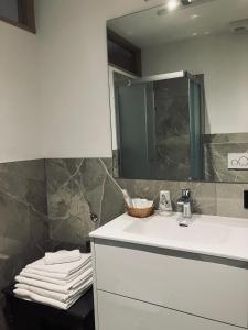 a bathroom with a sink and a mirror and towels at CERMIS Minisuite in Cavalese