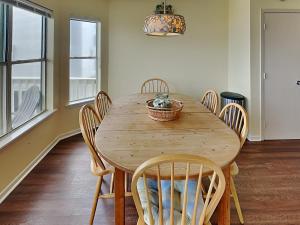 a dining room with a wooden table and chairs at Whispering Sands Beachfront in Galveston