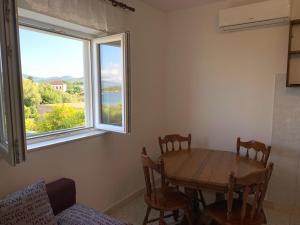 a table and chairs in a room with a window at Green Apartment in Sreser